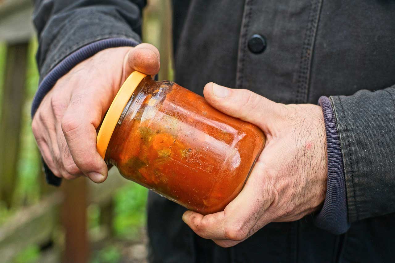 Mann versucht ein Glas mit beiden H&auml;nden zu &ouml;ffnen &ndash; Schwierigkeiten beim Greifen, typisch bei Rhizarthrose.