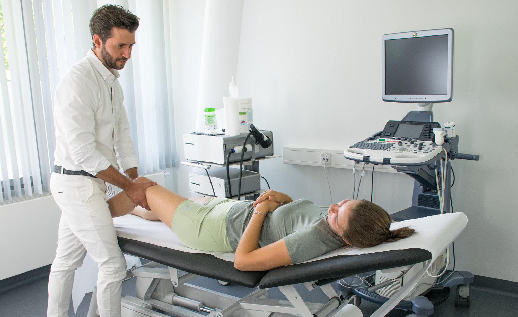 Das Knie der Patientin wird nach einer Sportverletzung vorsichtig von Dr. Bauer orthop&auml;disch untersucht.