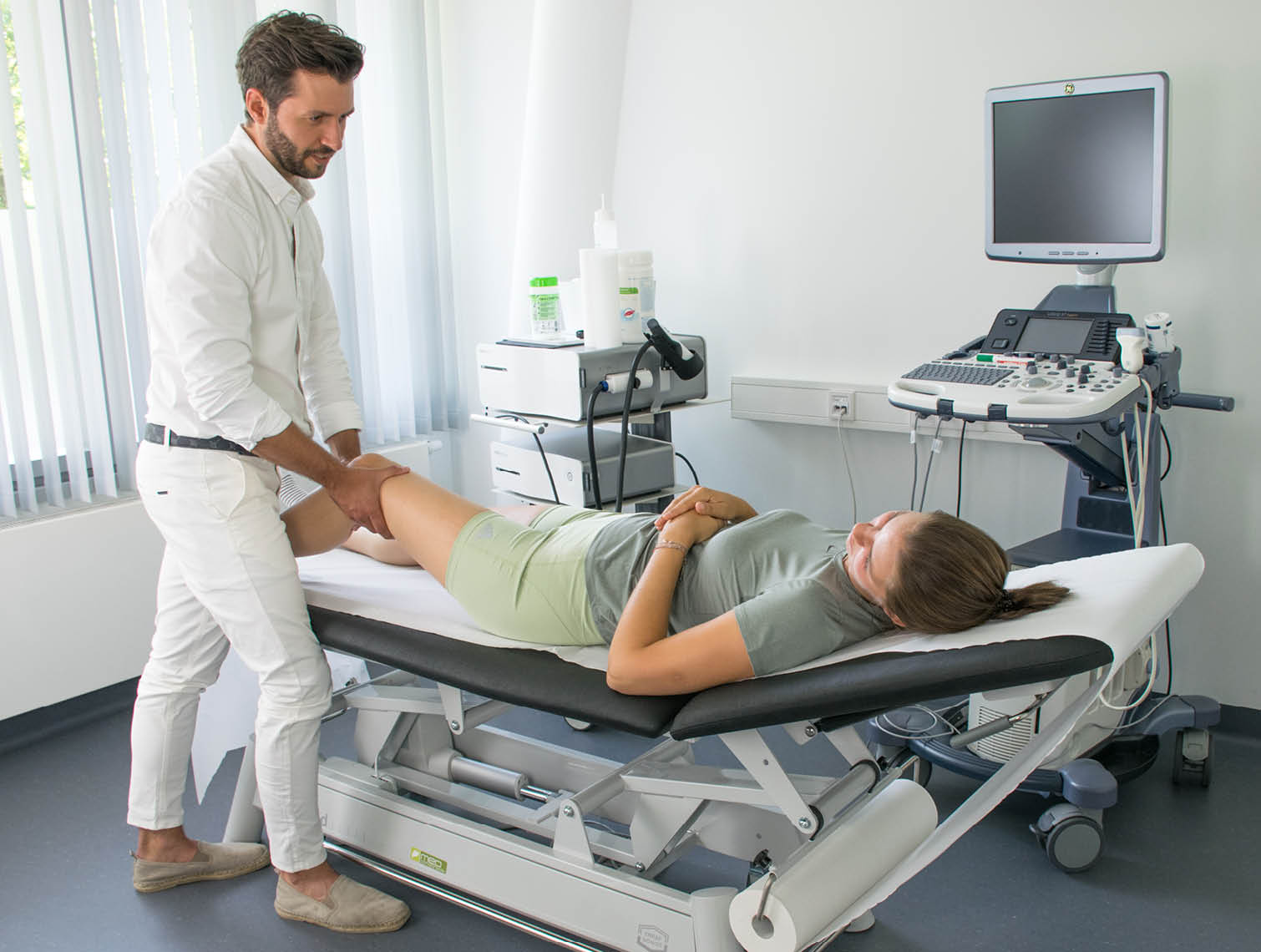 Das Knie der Patientin wird nach einer Sportverletzung vorsichtig von Dr. Bauer orthop&auml;disch untersucht.